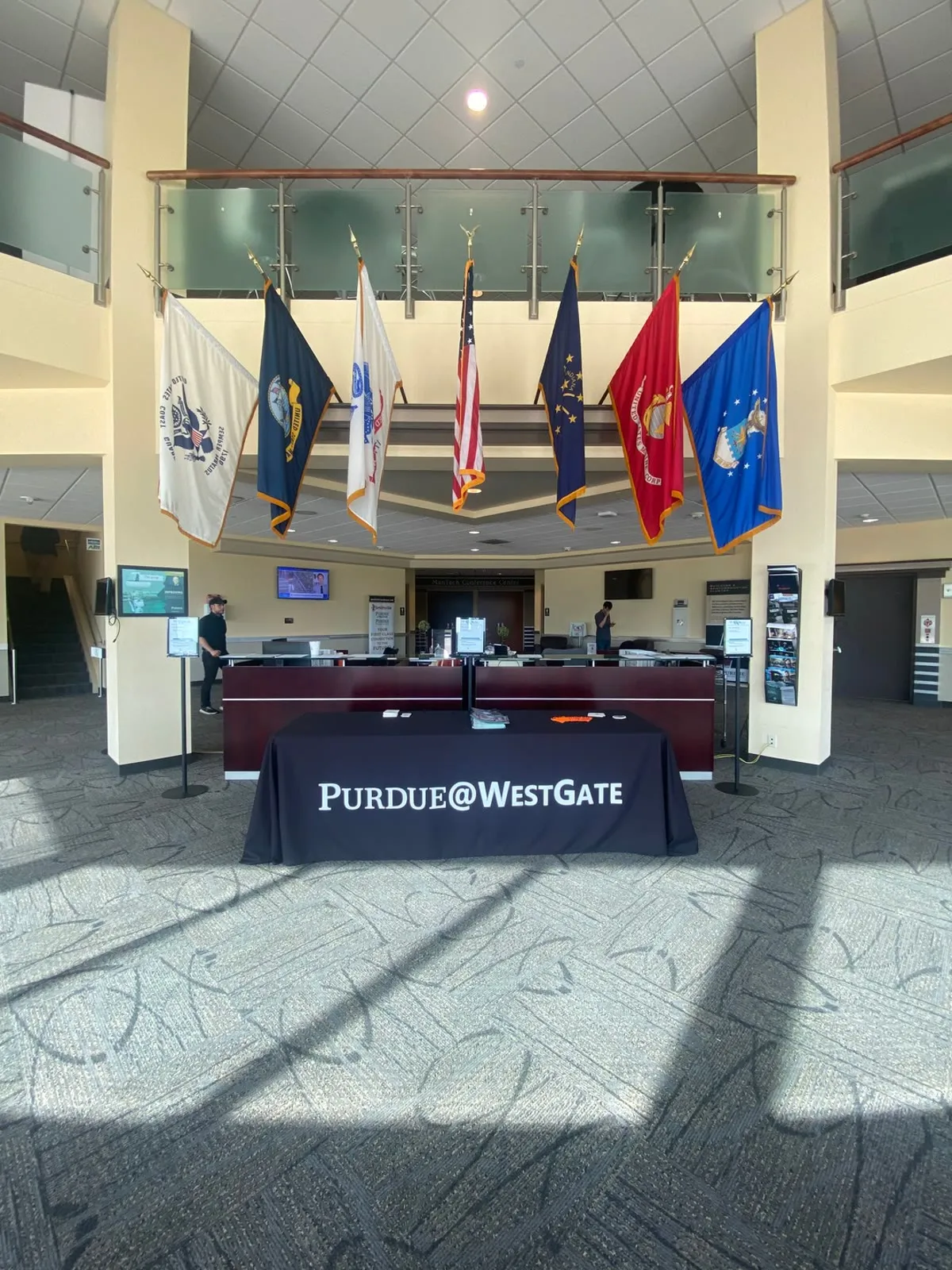 Flags and a Purdue@WestGate welcome table in the WestGate facility lobby.
